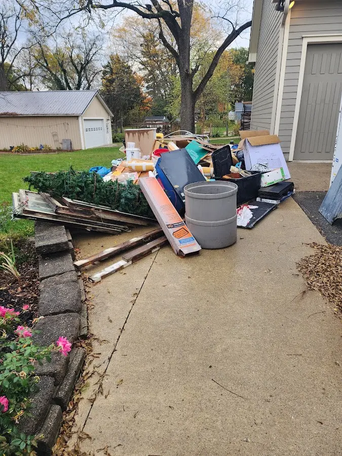 Dumpster being loaded with debris for Estate Cleanout Dumpster Rental in Maplewood